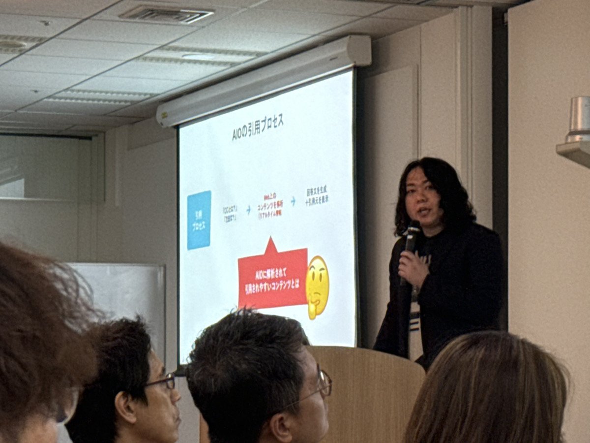 「AIOの引用プロセス」のスライドと「AIOに解析されて引用されやすいコンテンツとは」という吹き出しを示しながら解説する佐々木一郎
